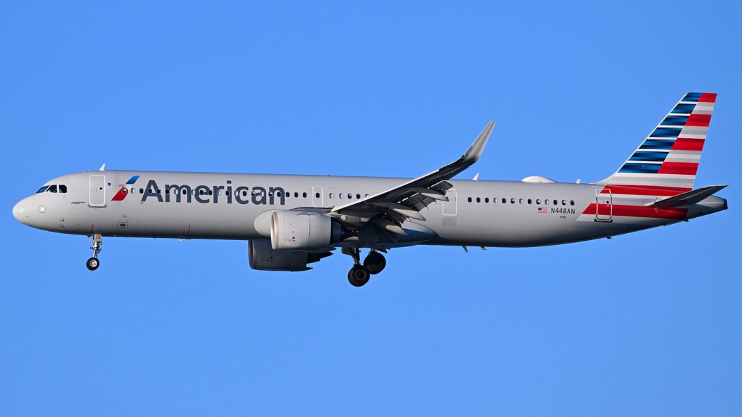 Malé lietadlo, veľký oceán. American Airlines priletí do Viedne Úzkotrupý Airbus A321neo spoločnosti American Airlines na finálnom priblížení, pohľad zdola na trup s logom dopravcu
