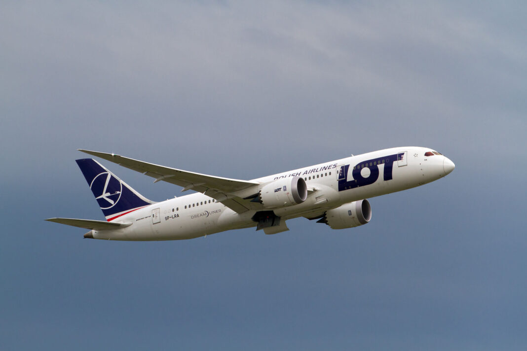Varšava sa mení na prestupný uzol medzi Amerikou a strednou Európou Boeing 787-8 Dreamliner poľského dopravcu LOT na stojisku, pohľad spoza krídla s viditeľným spojom krídla a trupu.