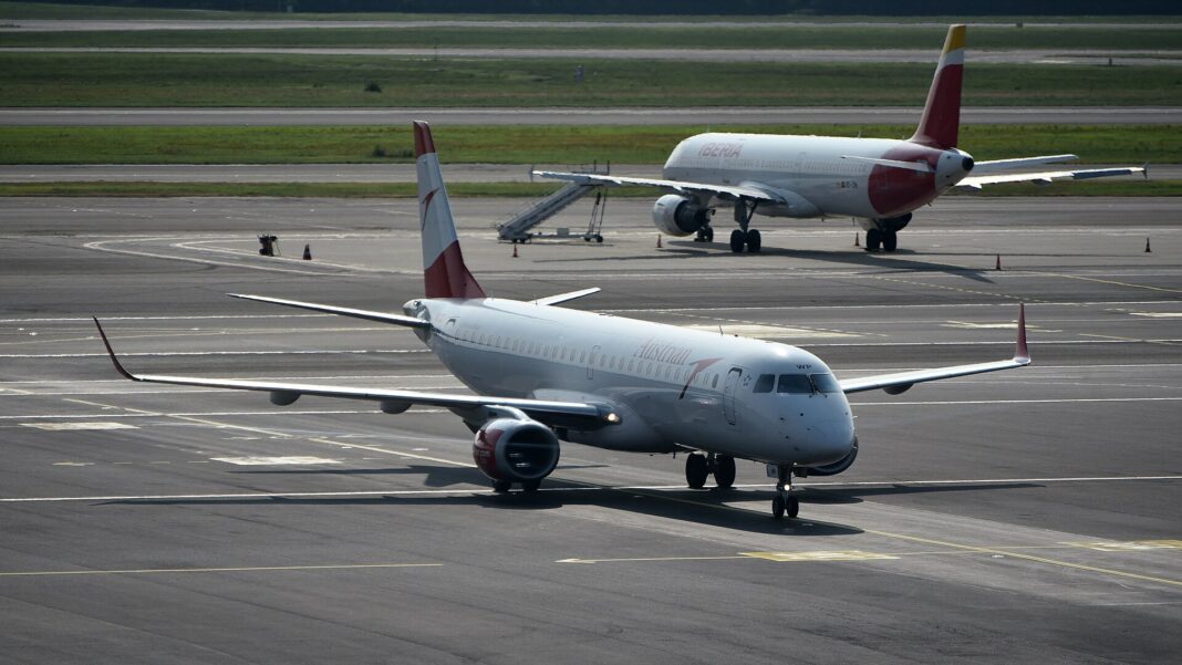 Dvetisíc E-Jetov od Embraeru, ani jedno stredné sedadlo Lietadlo Embraer 195 spoločnosti Austrian Airlines roluje k terminálu na letisku Miláno-Malpensa, záber spredu zboku v dennom svetle