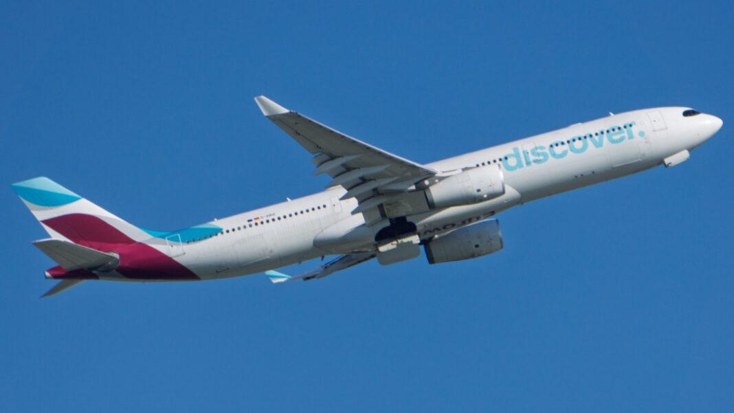 AeroSHARK A330 šetrí tony paliva ryhami tenšími než ľudský vlas Airbus A330-300 spoločnosti Discover Airlines stúpa po štarte, pohľad zdola zboku na jasnej modrej oblohe.