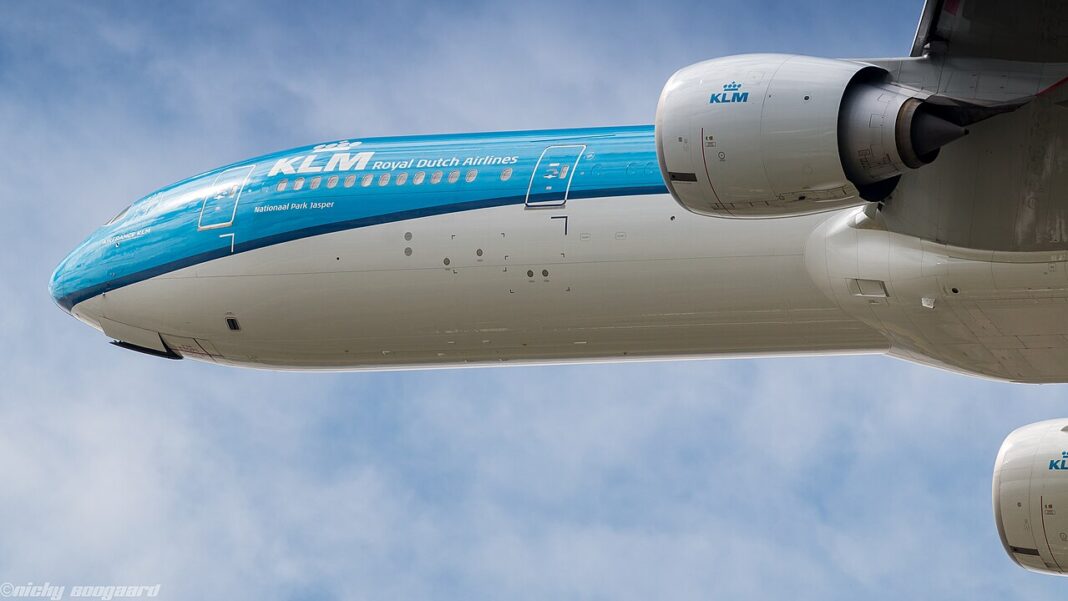 Exšéf KLM porušil zákaz nabíjania powerbaniek. Ide už o druhý požiar Boeing 777-300ER spoločnosti KLM krátko po vzlete, pohľad zospodu na trup, krídlo a oba motory na pozadí oblohy s ľahkou oblačnosťou.